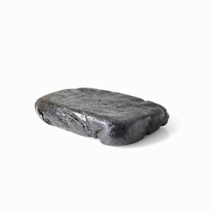 Solid block of dark licorice extract, a high-quality product for a natural health and wellness lifestyle.
