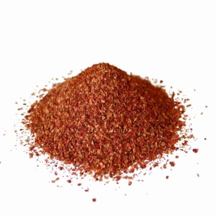 A pile of ground reddish-brown sumac, a nutrient-dense spice used for natural health and culinary wellness.