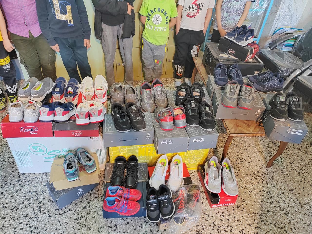 A group of children with new sneakers from a charity initiative, supporting local services and community wellness.