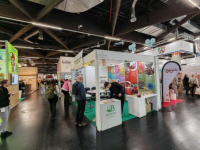 Besucher stöbern am Stand von Blumental Bayern nach Bio-Gesundheitsprodukten während einer lebhaften bayerischen Wellness-Messe.