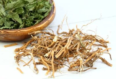 Dried Urtica dioica roots and leaves in a wooden bowl, featuring organic products for a natural health and wellness lifestyle.